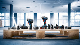 나무 팔레트가 밝고 현대적인 환경에서 다양한 전동 공구를 지탱하고 있습니다.