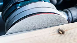 나무 판 위에 있는 Bosch Professional 샌더.