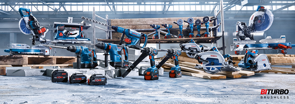 나무 기둥과 바닥 위에 있는 다양한 파란색 Bosch Professional 도구들.