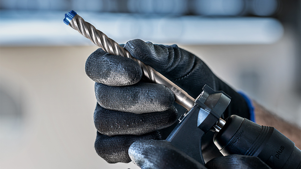 한 사람이 손에 Bosch Professional 드릴을 들고 있습니다.