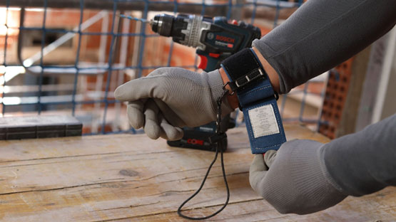 장갑을 낀 장인이 도구 팔찌를 착용하고 있습니다.