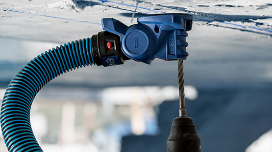 먼지 추출을 위한 호스가 있는 파란색 Bosch Professional 드릴.