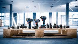 밝은 방에 나무 팔레트 위에 있는 Bosch Professional 도구.