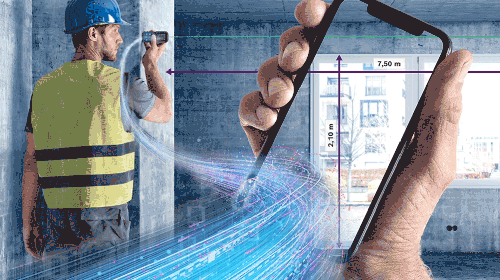 노란 조끼를 입은 장인이 방에서 스마트폰으로 측정하고 있습니다.