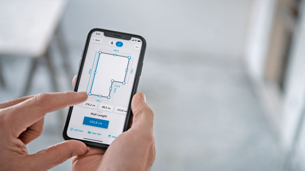 한 손이 공간 계획 앱이 있는 스마트폰을 들고 있습니다.