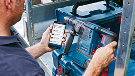 한 남자가 Bosch Professional 도구와 스마트폰을 사용하고 있습니다.