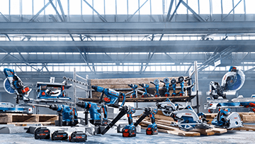 홀에 나무 팔레트 위에 여러 개의 Bosch Professional 도구가 있습니다.