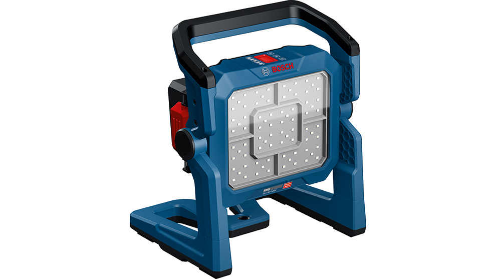 파란색 Bosch Professional 배터리 작업 조명이 회색 바닥 위에 안정적으로 서 있으며, 큰 조명 영역을 가지고 있습니다.