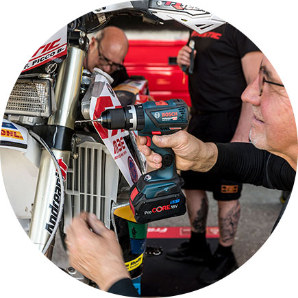 한 남자가 오토바이에 보쉬 프로페셔널 무선 드릴을 사용하고 있습니다.