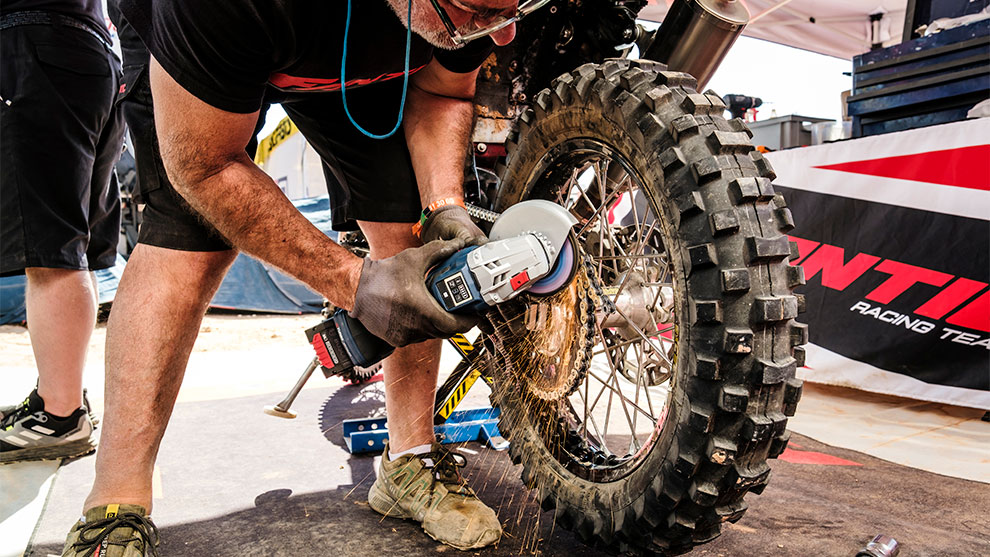 정비사가 보쉬 도구로 오토바이 타이어를 연마하고 있습니다.