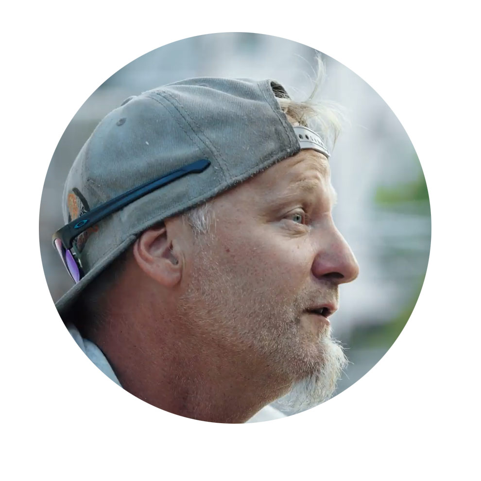 니코 뵈슬, 트랙 디자이너 회색 모자를 쓴 남자가 말하고 있으며, 얼굴은 옆으로 향하고 미소를 짓고 있습니다.